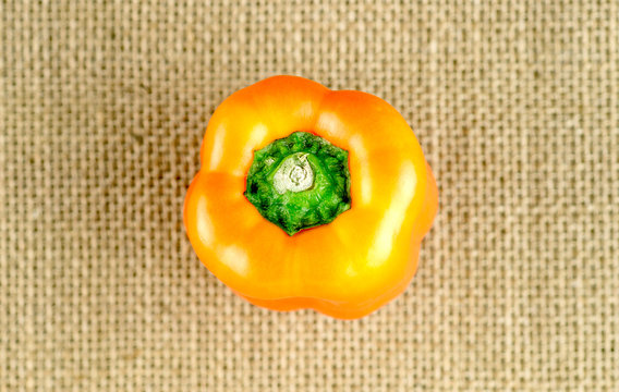 Aerial of yellowish orange bell pepper with bright green stem