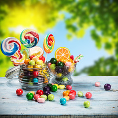 multicolored lollipops, candy and chewing gum in glass jar