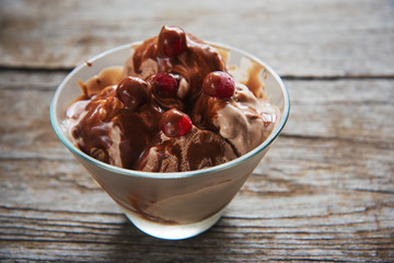 chocolate ice cream with syrup and frozen cherries
