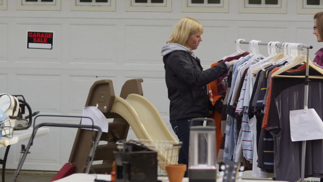 Women shop for clothing at yard sale