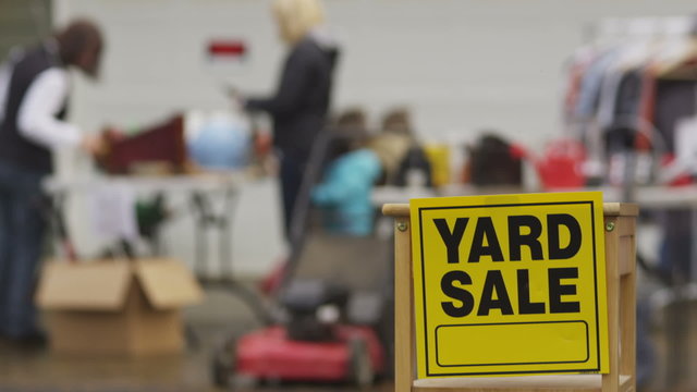 Yard Sale sign with people in background