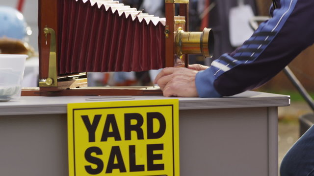 Man at yard sale inspects antique camera