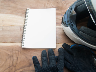 black gloves motorcycle and white helmet and white book on wood