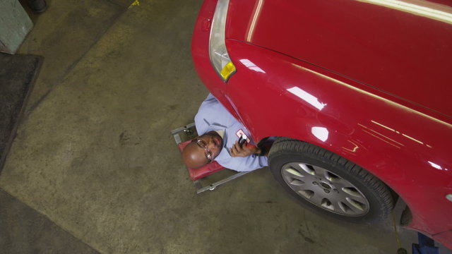 High angle shot of auto mechanic checking car