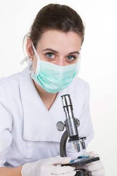 Female medical doctor using microscope in a laboratory on white