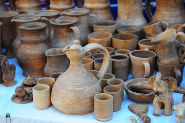 Fototapeta na wymiar Close up on Traditional Ceramic Jugs on Decorative Towel. Showcase of Handmade Ukraine Ceramic Pottery in a Roadside Market with Ceramic Pots and Clay Plates Outdoors.