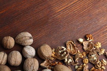 walnuts are broken on a brown wooden table