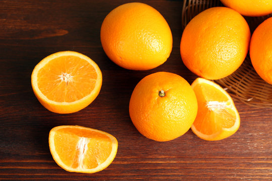 delicious sliced oranges lay in a heap on brown wooden table