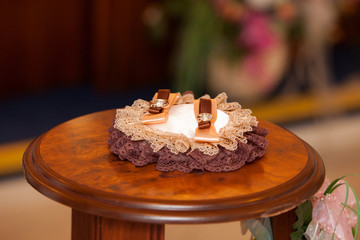 wedding rings on a brown pillow