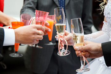 Wedding greeting with glasses of champagne. The company of the friends of the bride and groom. Alcohol at the wedding.