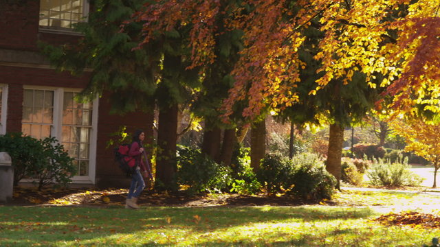 College student walking through campus in fall