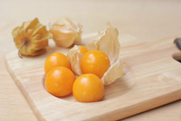Cape gooseberry (Physalis) on wooden plate