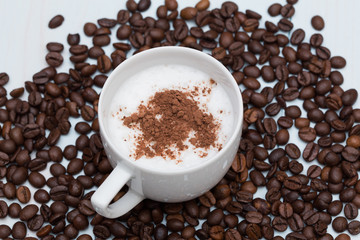 Cup of cappuccino coffee with beans