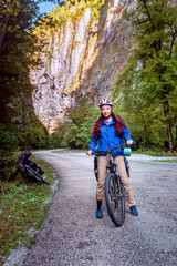 Fototapeta premium Lady traveler with bicycle in the rocky gogre at sunny day