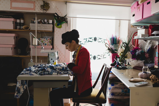 Woman sewing with a sewing machine in his workshop