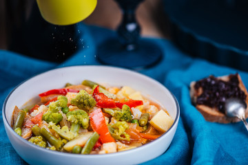 Fresh vegetarian soup in white bowl on blue tablecloth