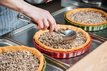 Cheif cook making pie with meat filling on the kitchen