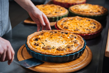 Delicious pies on wooden coasters at kitchen in restaurant