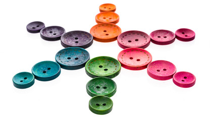 Different color star shaped sewing buttons in a flower shape.