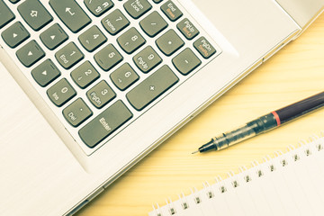 Silver Laptop and Notebook and Pen on Wood Table Vintage