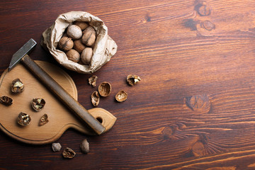 very delicious and healthy pile of broken walnuts on a wooden cutting Board with a hammer and in the package