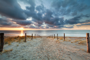 chemin romantique à la plage de sable au coucher du soleil