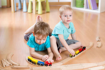 kids boys play with railroad and trains indoor, learning and daycare