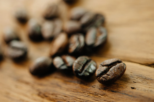 Coffee beans on wooden background with shallow DOF