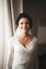 Fototapeta premium Portrait of beautiful bride with fashion veil at wedding morning. Wedding dress
