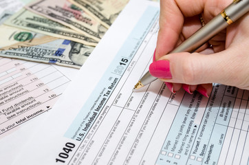 Business woman working with tax form documents with money