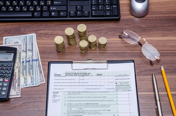 Fototapeta na wymiar 1040EZ income tax form with money, pen on table