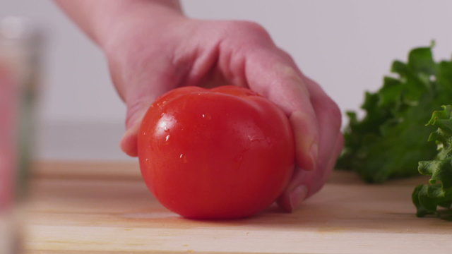 Slicing fresh tomatoes, closeup