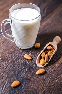Almond milk and nuts over rustic wooden background