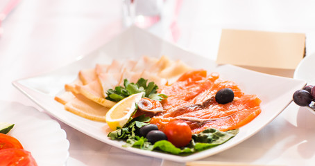 catering platter of sliced cured meat and fish  with vegetable decoration on easter table