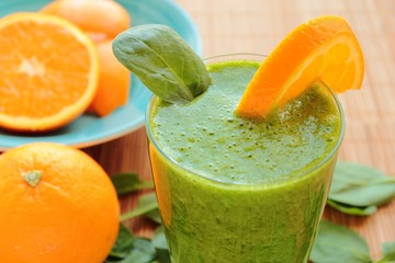 Healthy smoothie with spinach leafs and orange fruit