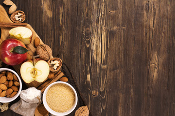 Apple pie ingrediens over brown wooden background. Baking concept background