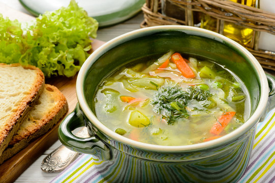 Spring vegetable soup in green bowl.