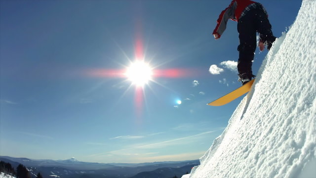 Snowboarder jumps off snow cliff, slow motion