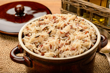 Boiled 3 color mixed rice in ceramic bowl on wooden table.