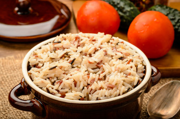 Boiled 3 color mixed rice in ceramic bowl on wooden table.
