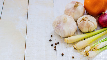 garlic bulb and spicy herb on white wooden background