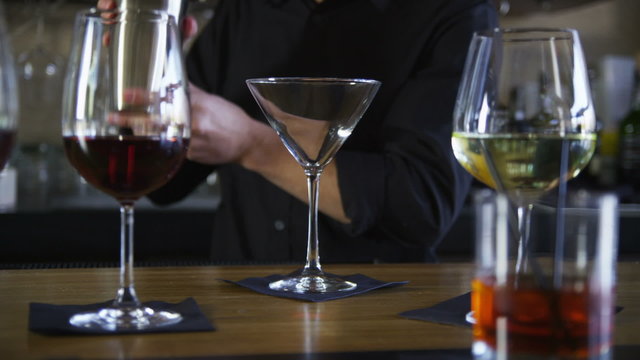 Bartender making a martini at bar