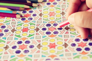 image of woman coloring, adult coloring book trend, for stress relief. selective focus 