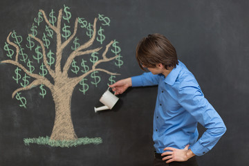 Photo of young businessman on chalkboard background. Dollar tree