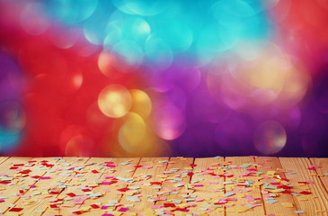 pink party whistle on wooden table with colorful confetti. vintage filtered image
