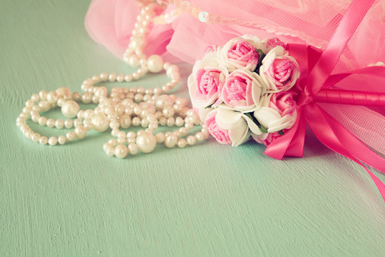 Small girls party outfit: crown and wand flowers on wooden table. bridesmaid or fairy costume