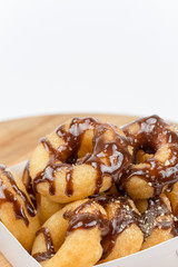 Box with donuts topped with chocolate cream isolated on white