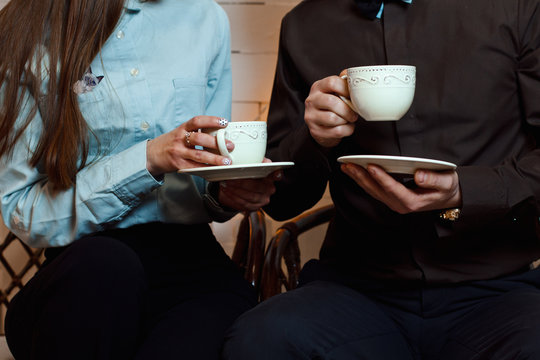man and woman in business suits are drinking tea (coffee)