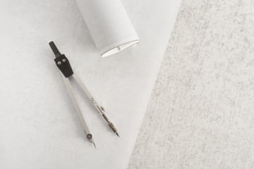 Architecture or design tools. Compass and papers on stone table. Concept of drafting, construction planning and drafting.