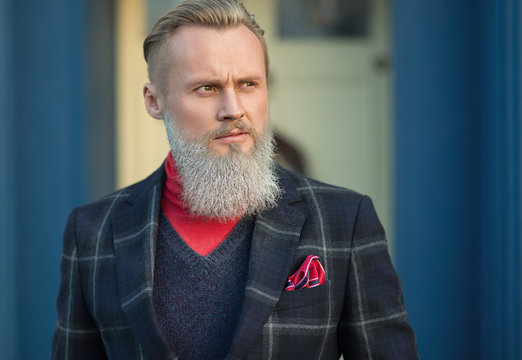 Portrait of a well-dressed bearded hipster man wearing a fashionable suit
